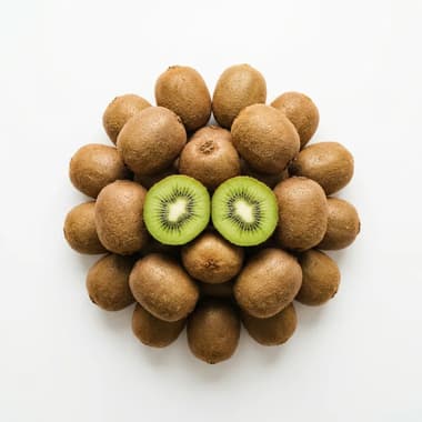 A round pile of whole kiwi fruits with two halves showing green flesh, on a plain white background